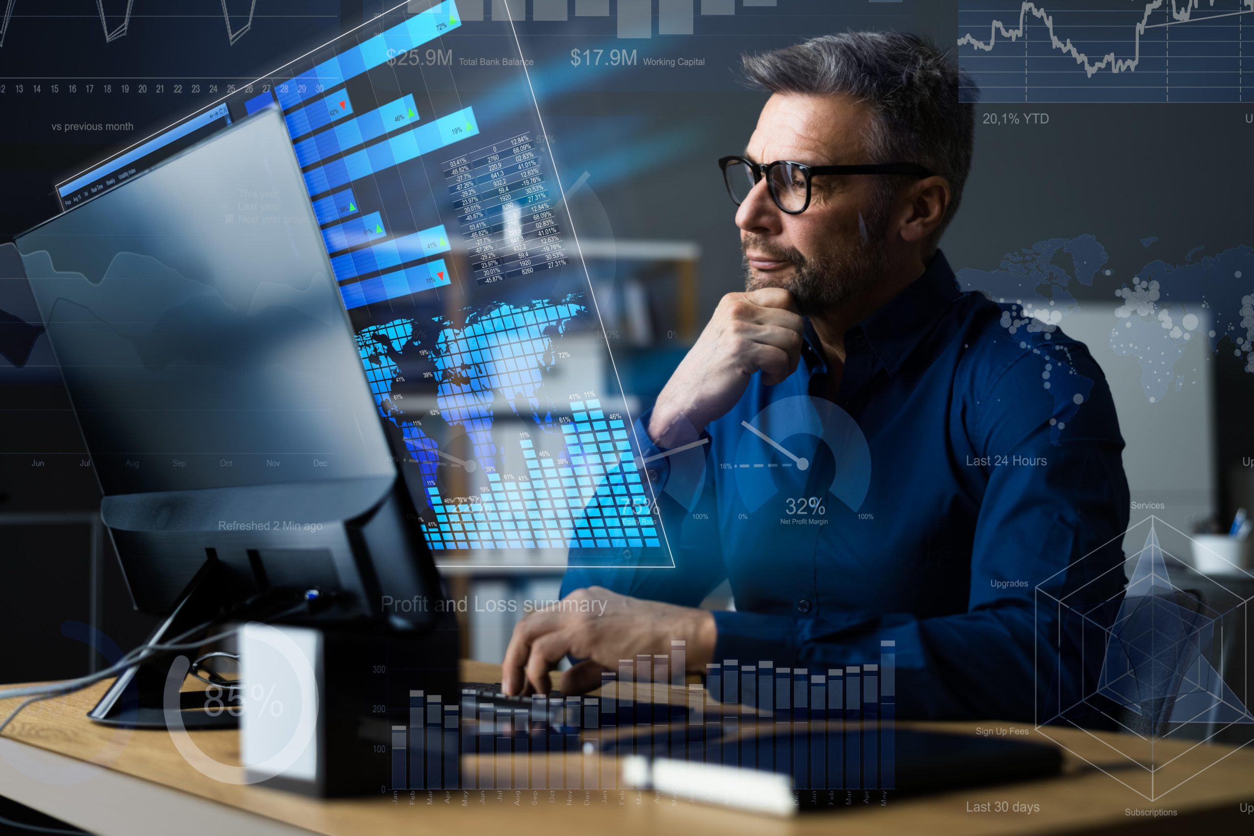 Un hombre de negocios, con gafas y con el dedo en el mentón, examina un panel de control digital de análisis de datos con gráficos y cifras financieras proyectadas delante de él.